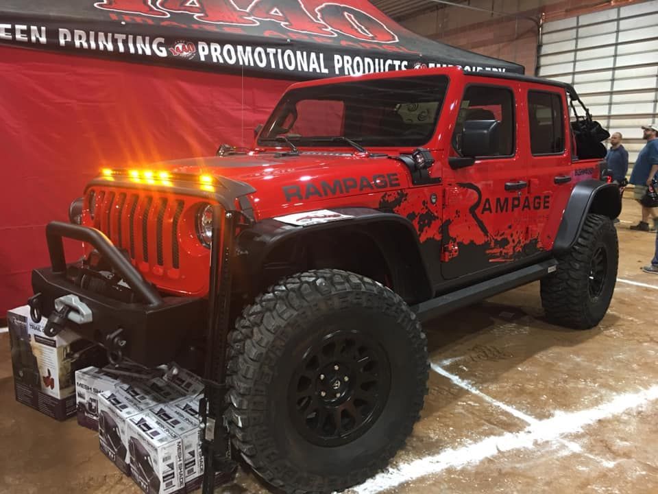 Red custom Jeep Wrangler with black off-road wheels and 