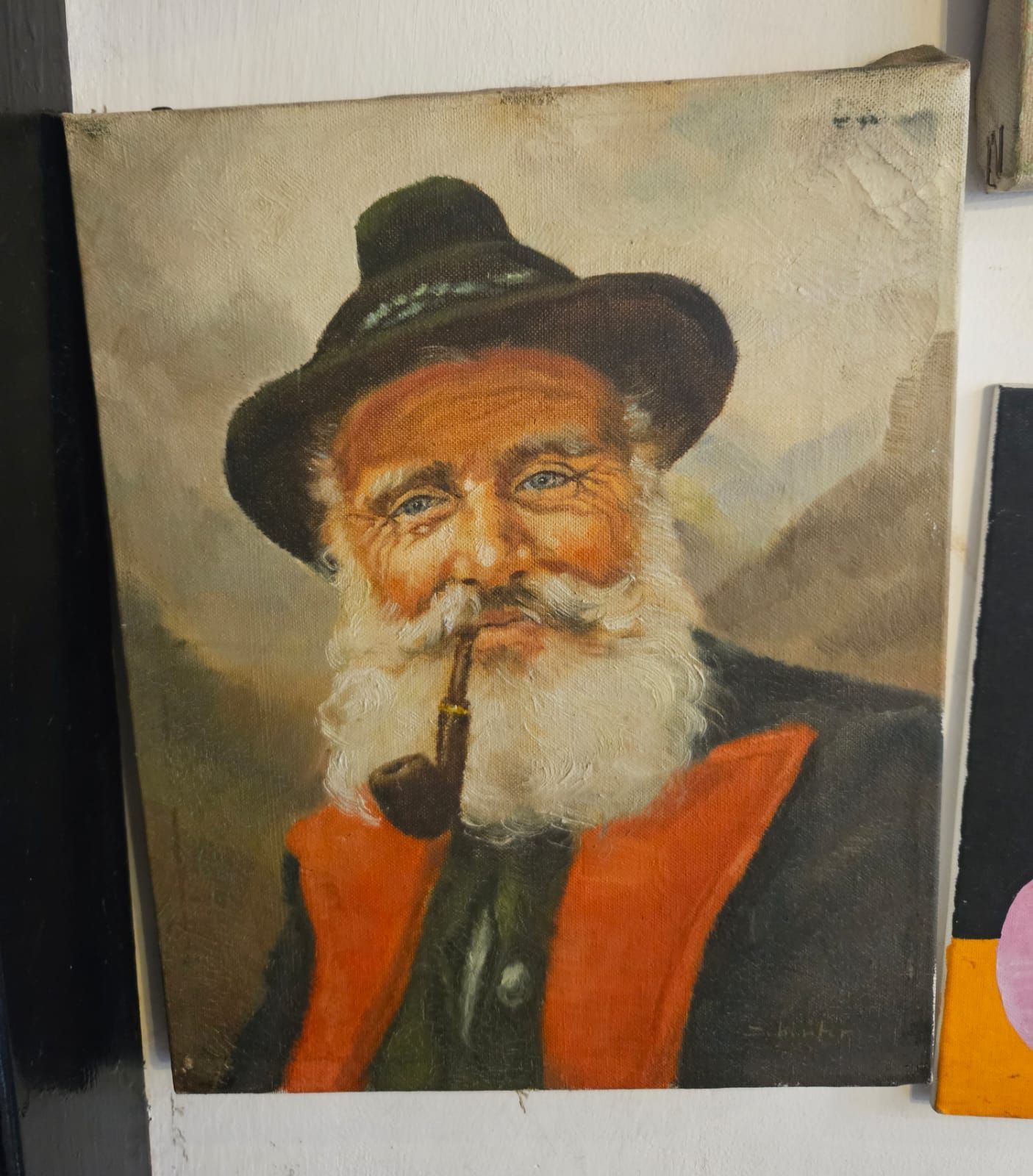 Dipinto a olio raffigurante un uomo sorridente con la barba bianca, un cappello, che fuma la pipa e indossa un cappotto arancione e nero.