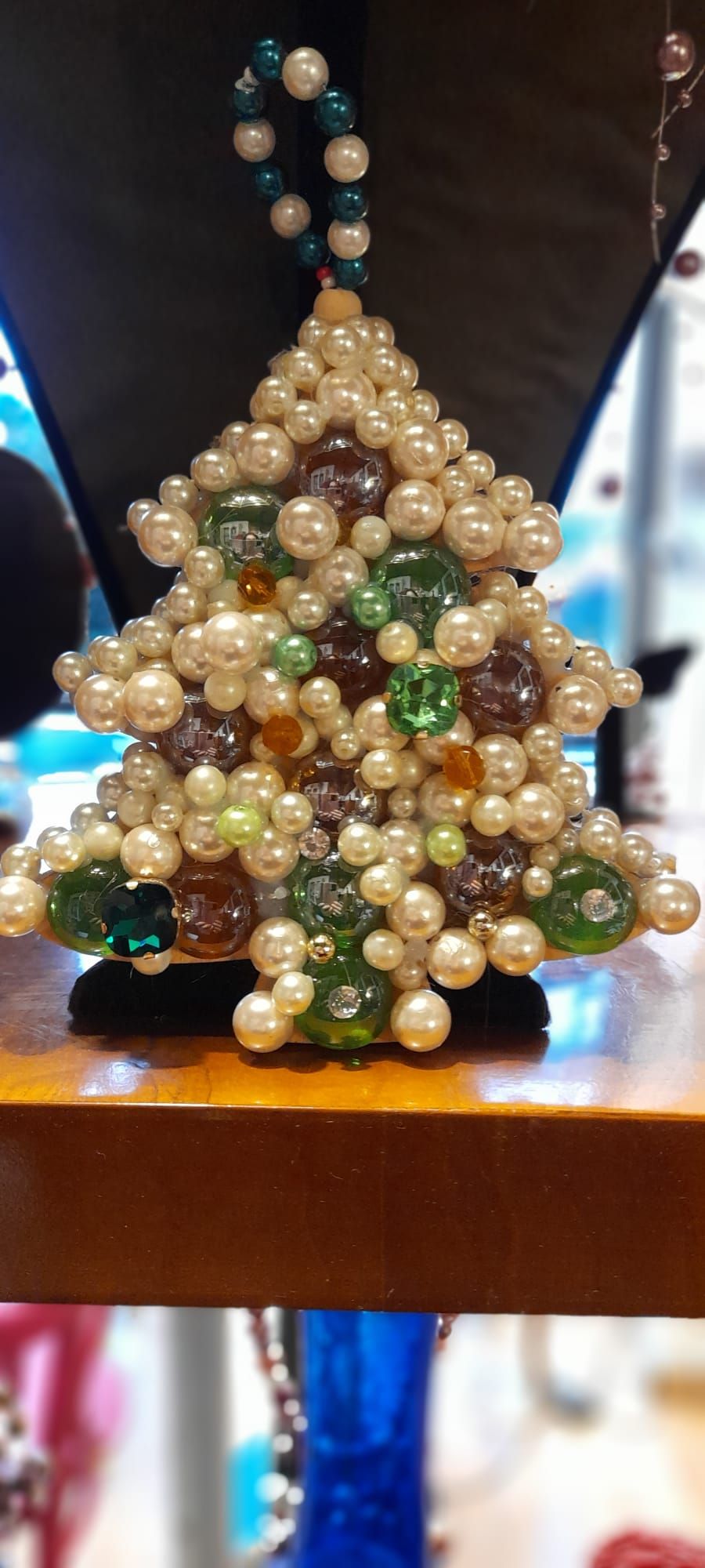 Decorazione per l'albero di Natale con perline bianche, verdi e marroni in mostra.