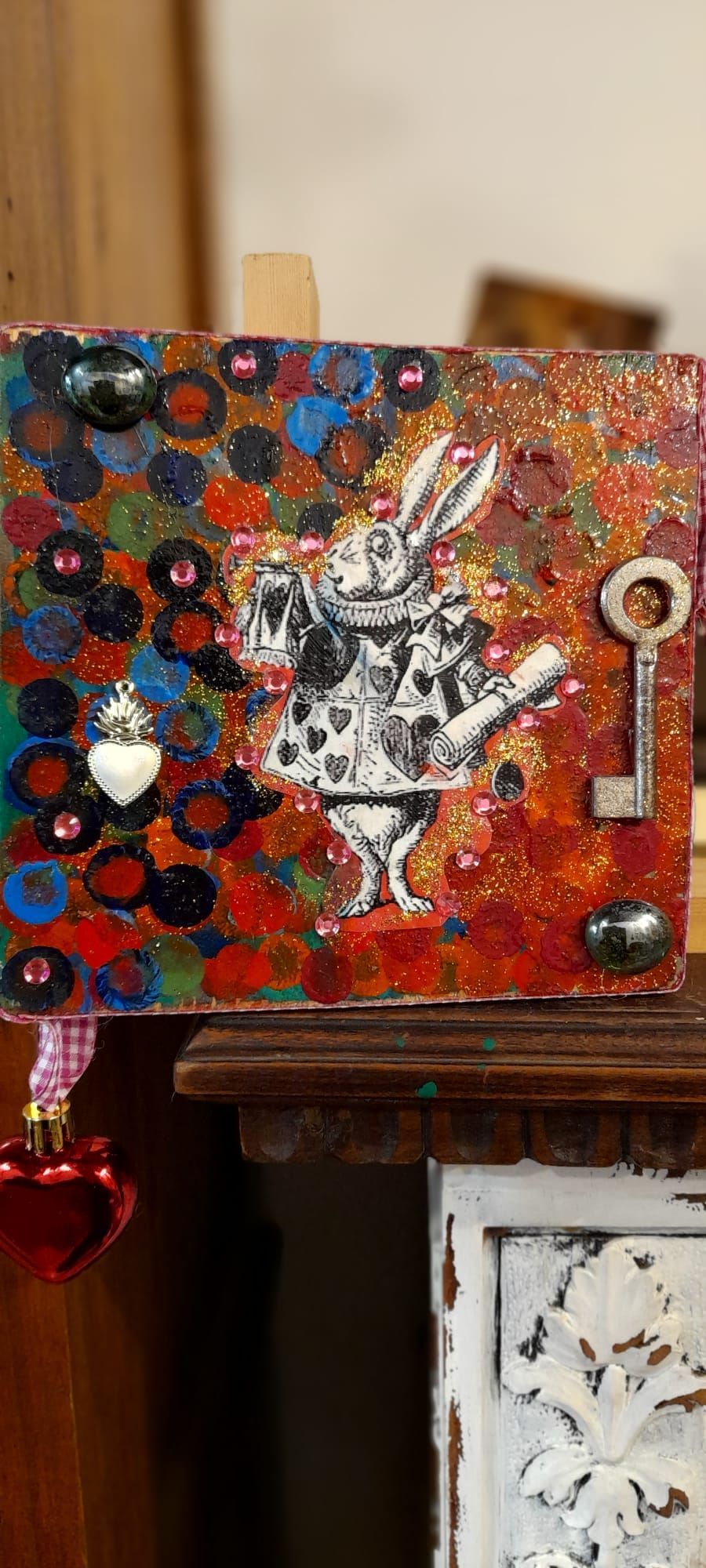 Un'opera d'arte realizzata con tecnica mista raffigurante il Bianconiglio di Alice nel Paese delle Meraviglie, abbellimenti e una chiave.