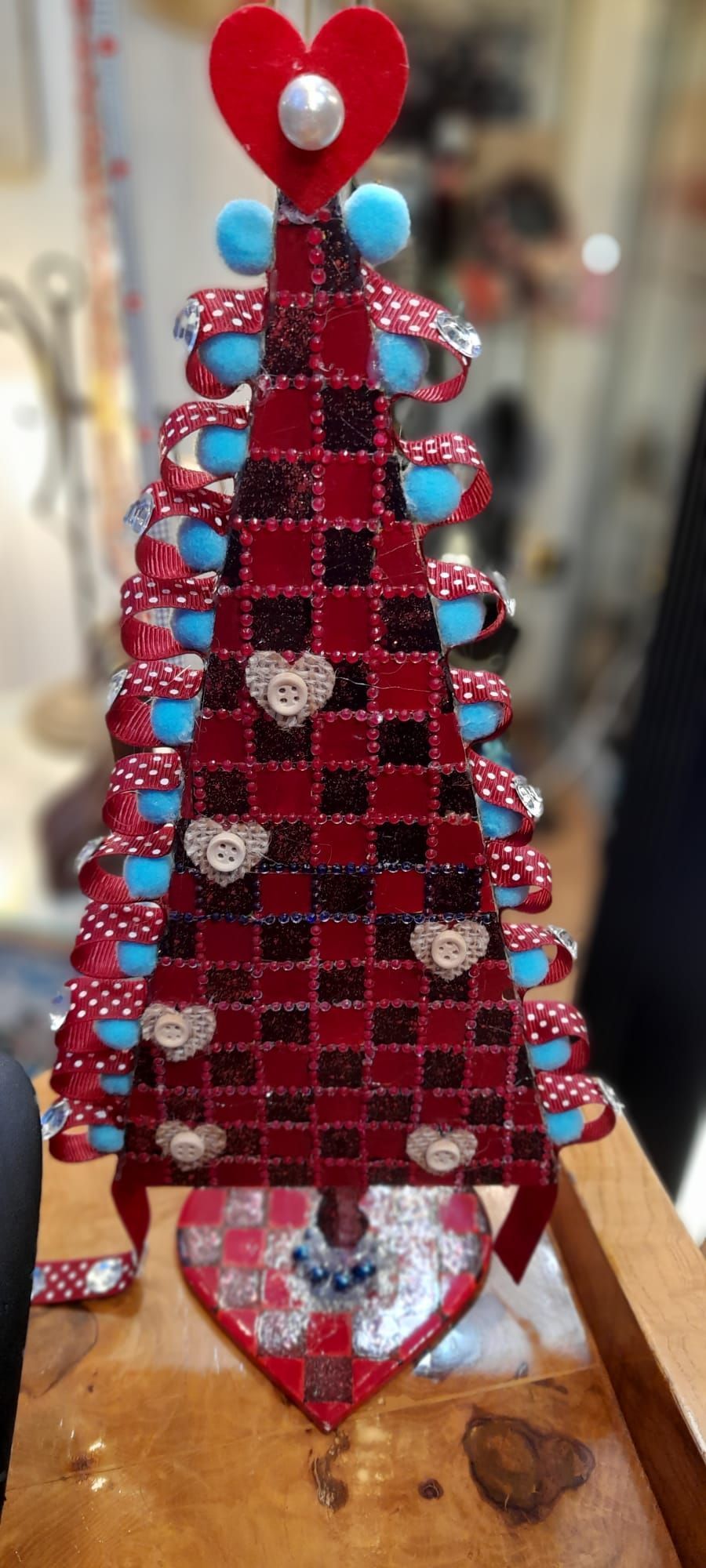 Decorazione per albero di Natale a quadri rossi e neri con cuori, tazze e una base a forma di cuore.