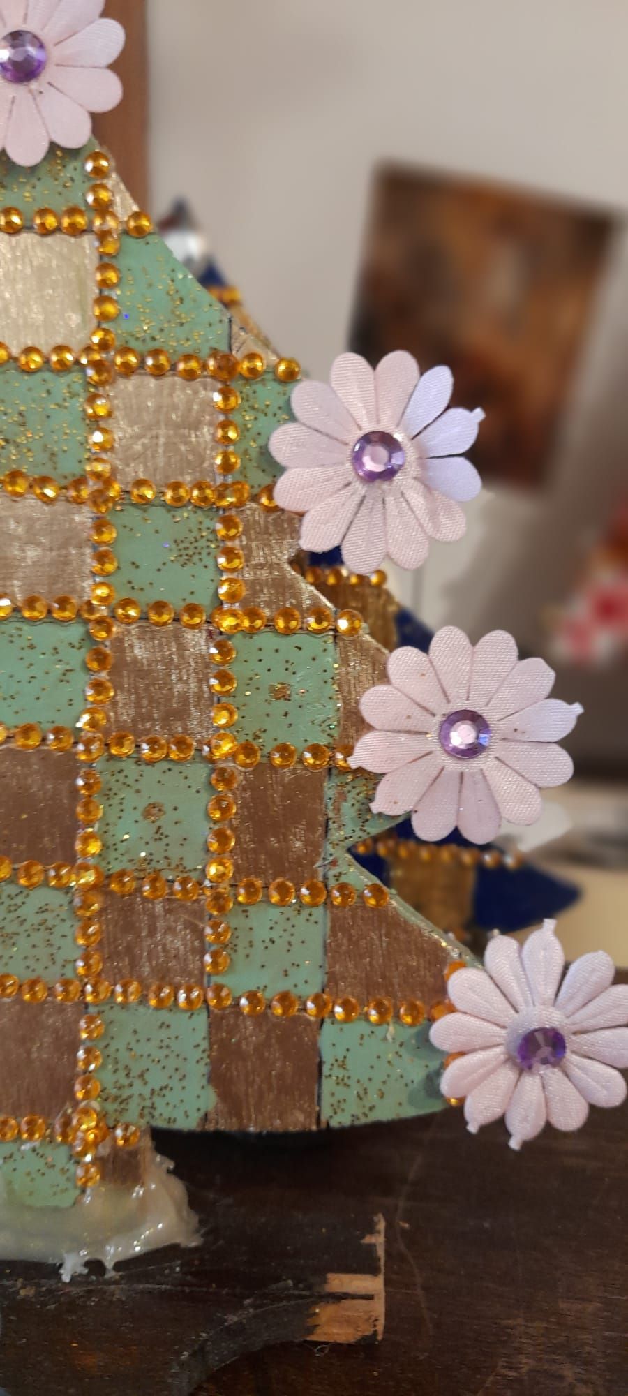 Albero di Natale decorato con fiori di lavanda e dettagli dorati su una superficie di legno.