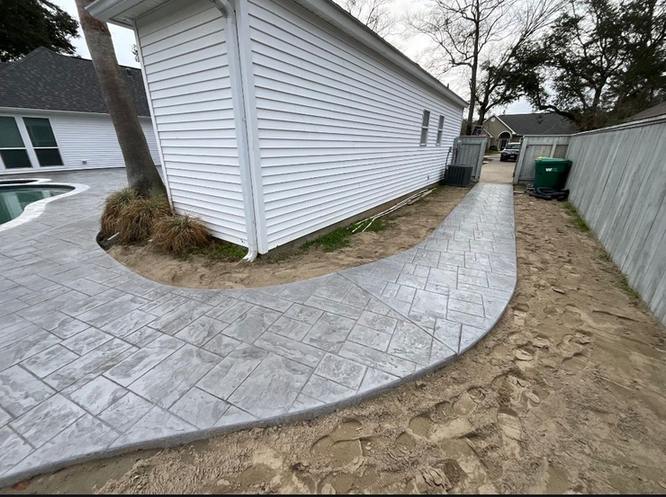 Curved gravel path beside a white lattice fence and shrubs in a yard
