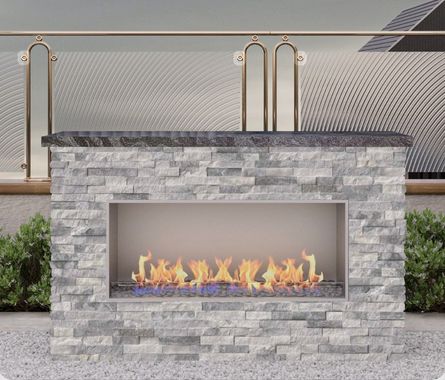Modern stone outdoor fireplace with a glass-front fire burning on a patio
