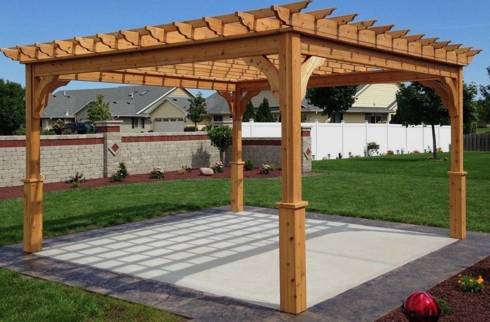 Wooden pergola over a concrete patio in a landscaped backyard