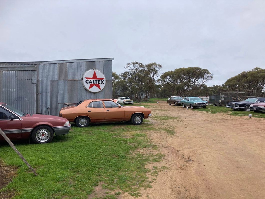 7 cars parked on a farm 