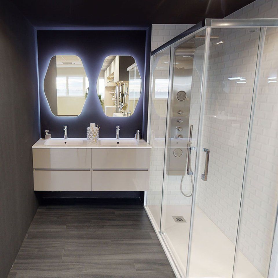 Bagno moderno con doppio lavabo, specchi ovali e box doccia in vetro.