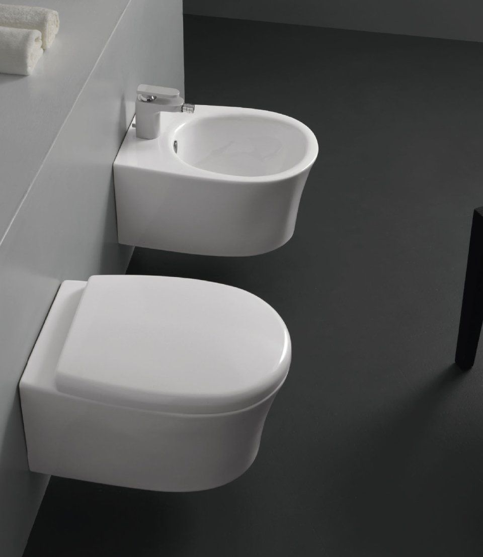 WC sospeso bianco e piccolo orinatoio in un bagno moderno, visti dall'alto.