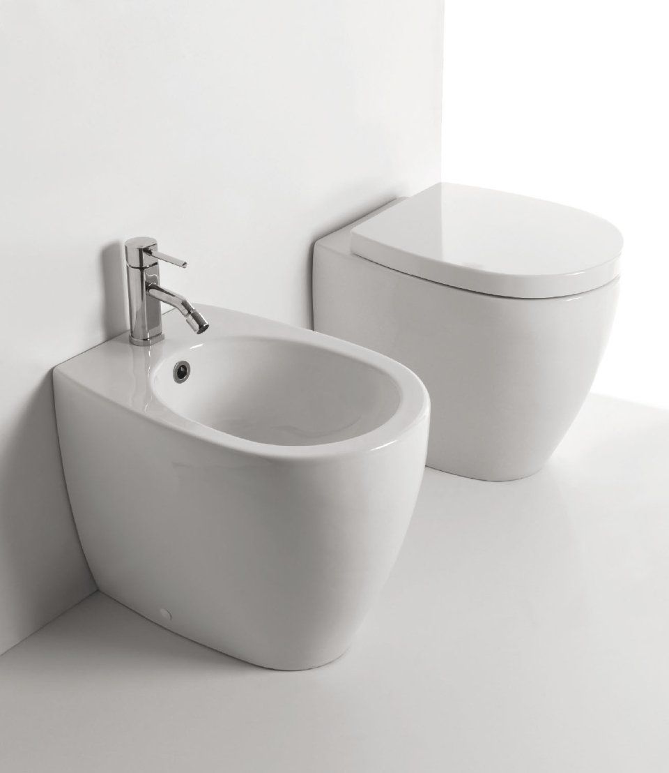 Bidet e WC moderni in ceramica bianca in un bagno pulito.
