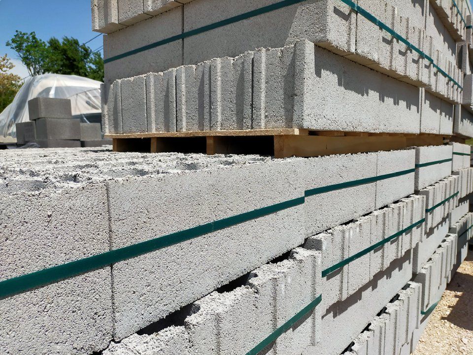 Blocchi di cemento impilati su pallet in un cantiere.