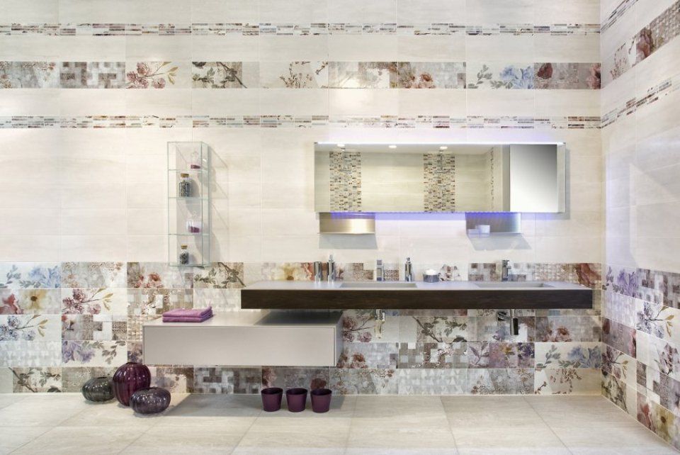 Bagno moderno con pareti rivestite con piastrelle floreali, mobile sospeso, armadietto con specchio e lavabo bianco.