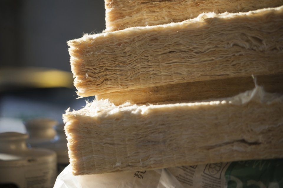 Primo piano di materiale fibroso beige impilato con bordi sfrangiati in luce calda