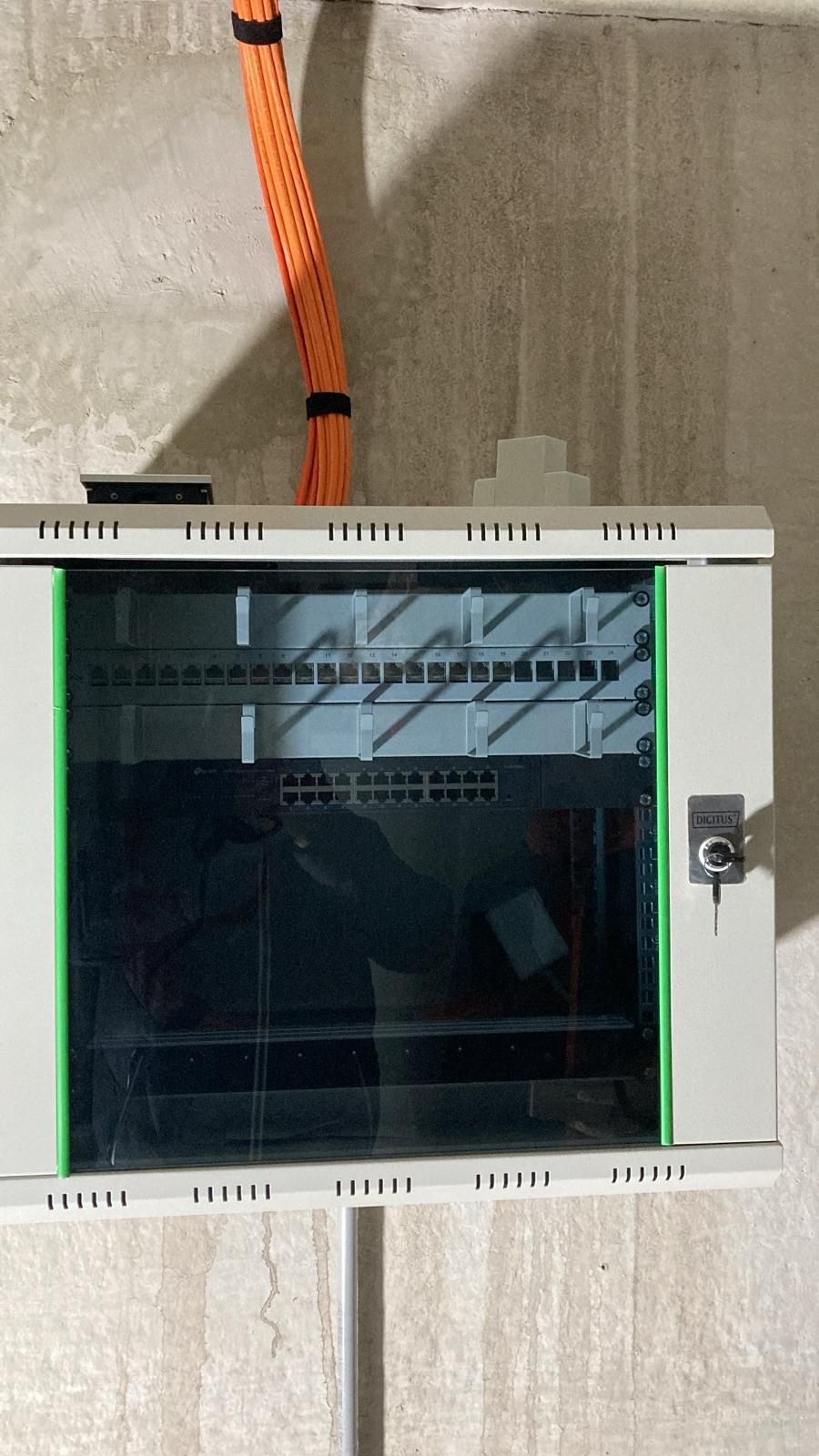 A white cabinet with a green trim is hanging on a wall.