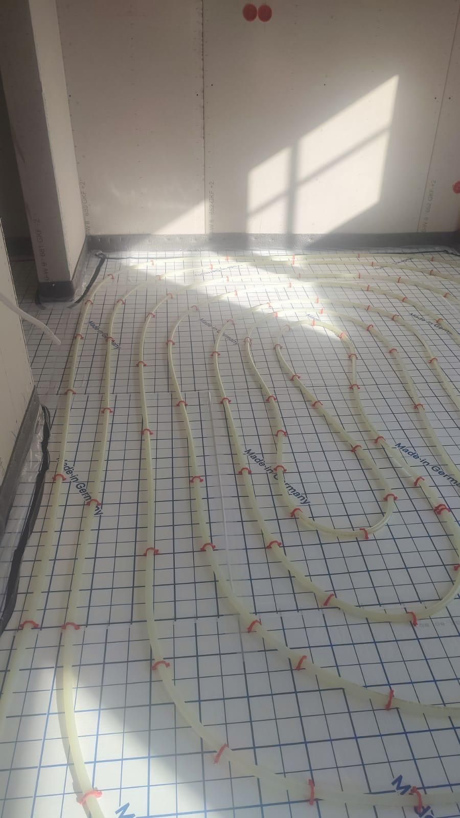 A room with a tiled floor and a lot of pipes on it.