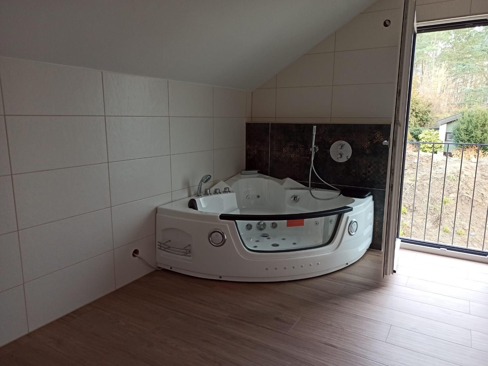 A bathroom with a jacuzzi tub and a balcony.