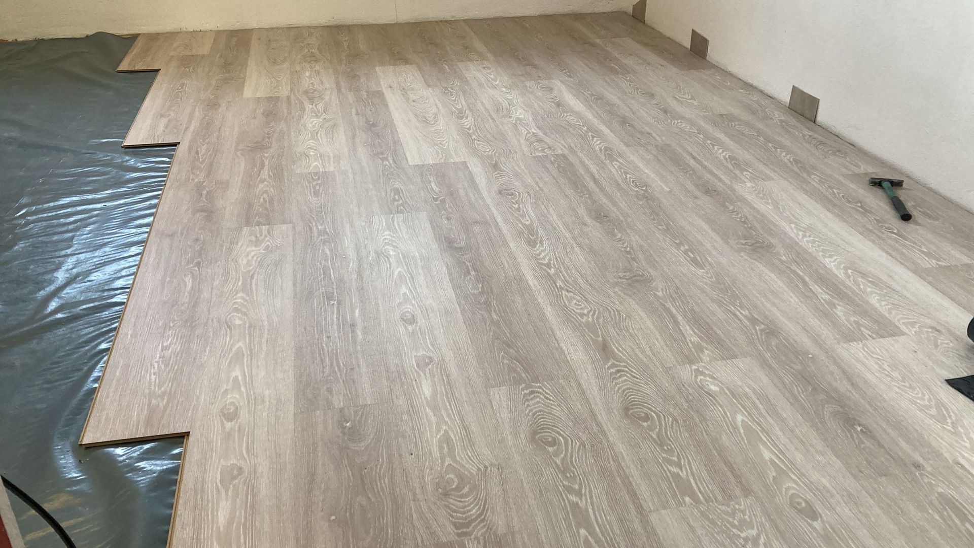 A wooden floor is being installed in a room.