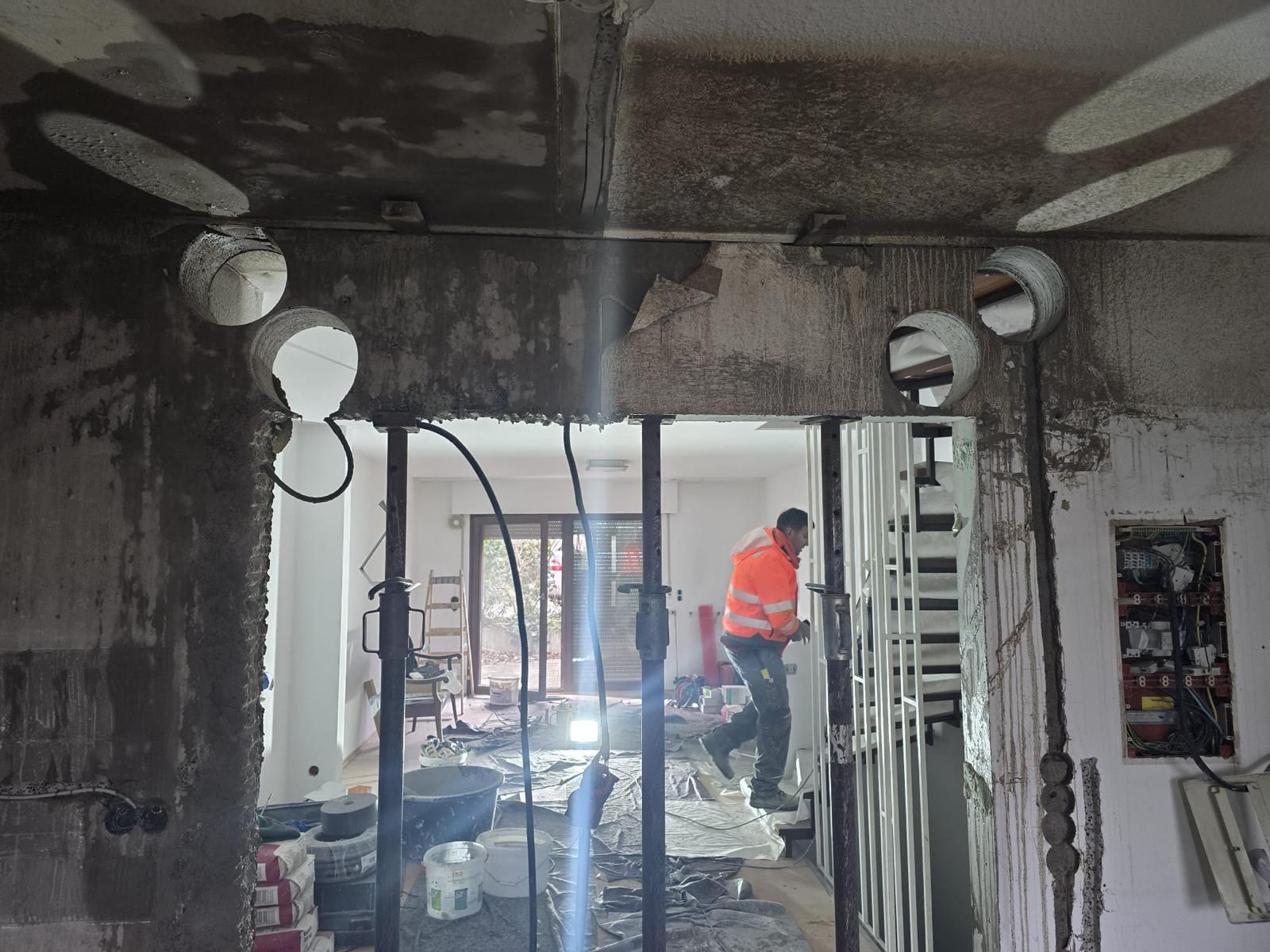 A man is standing in a room with a hole in the wall.
