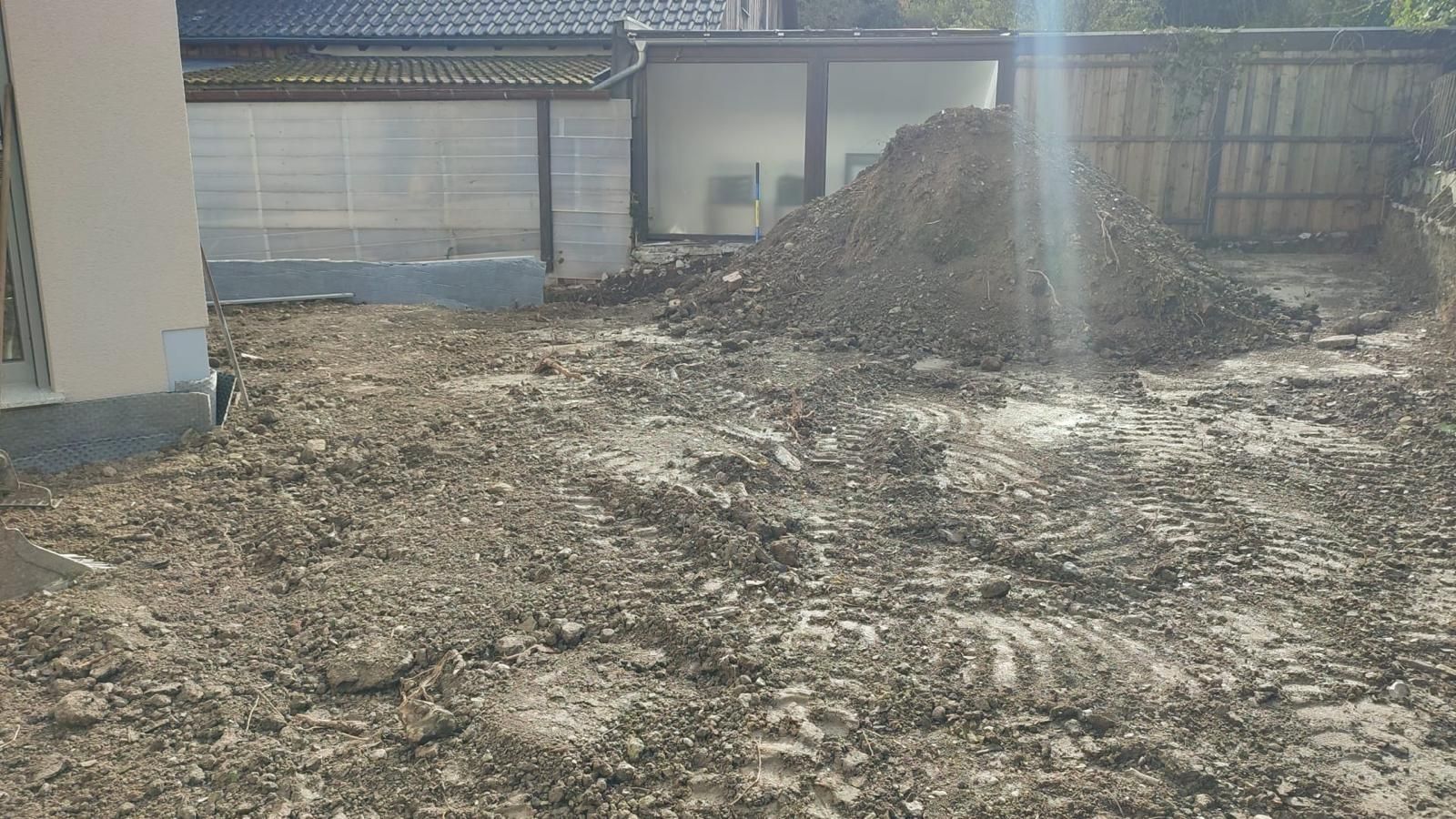 A pile of dirt is sitting on the ground in front of a building.