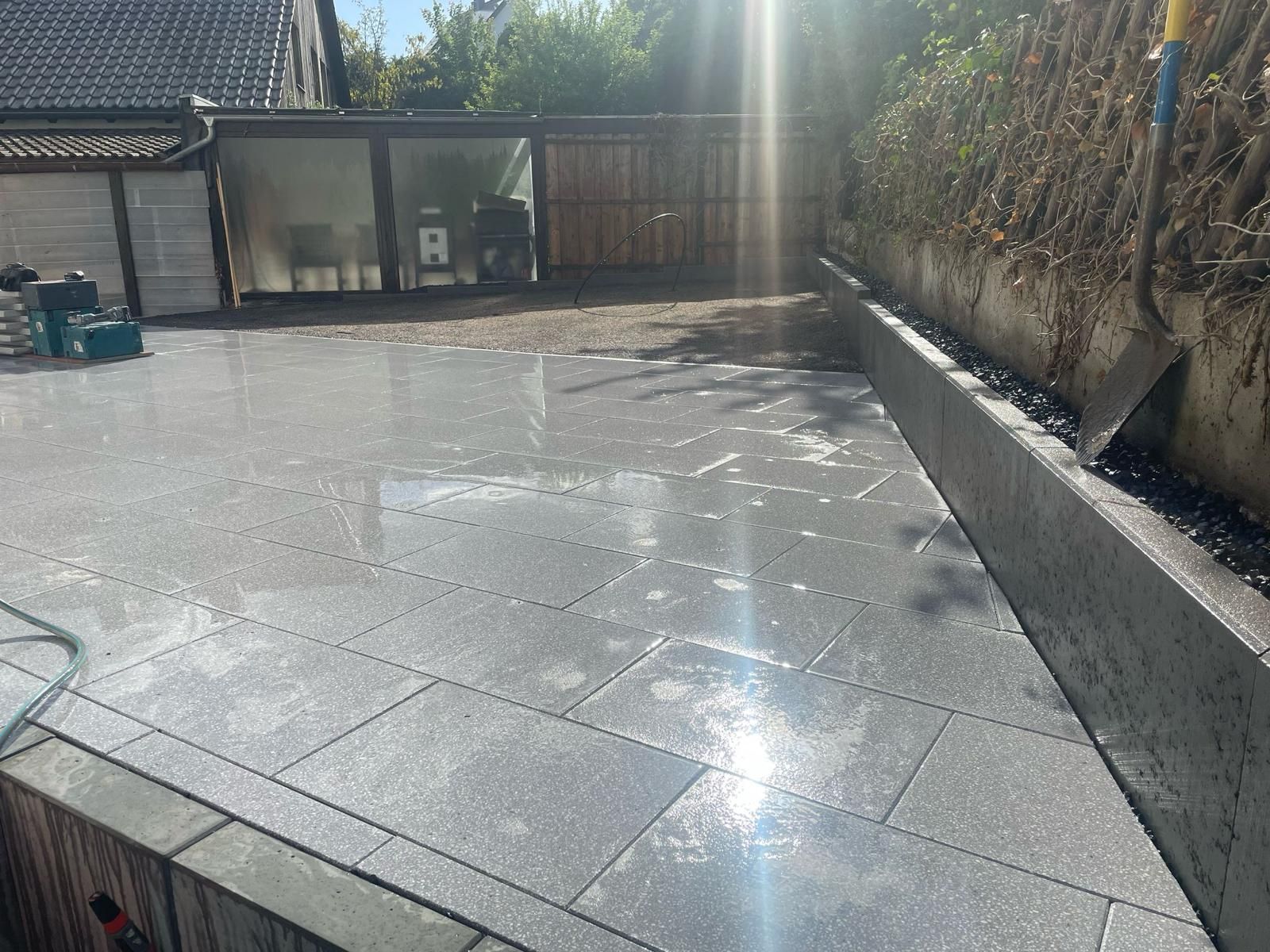 A patio is being built in the backyard of a house.