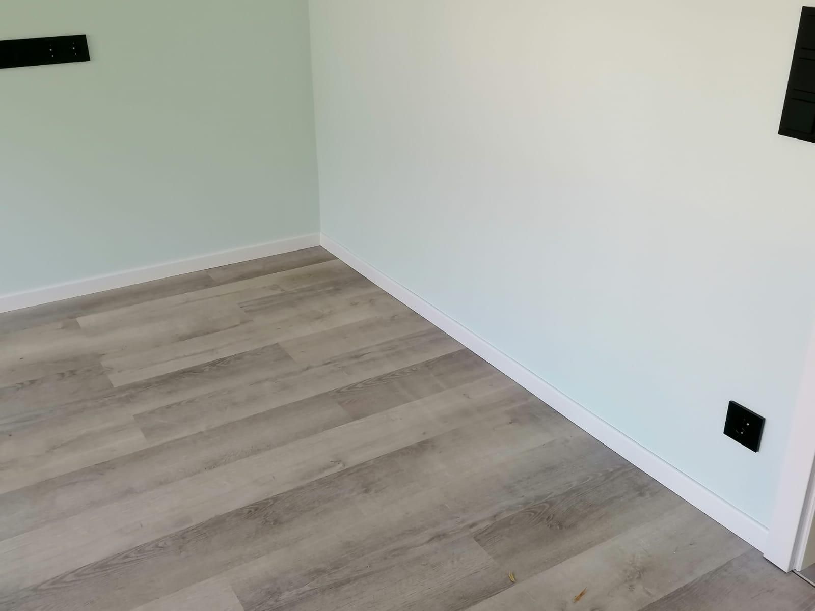 A room with a wooden floor and white walls.