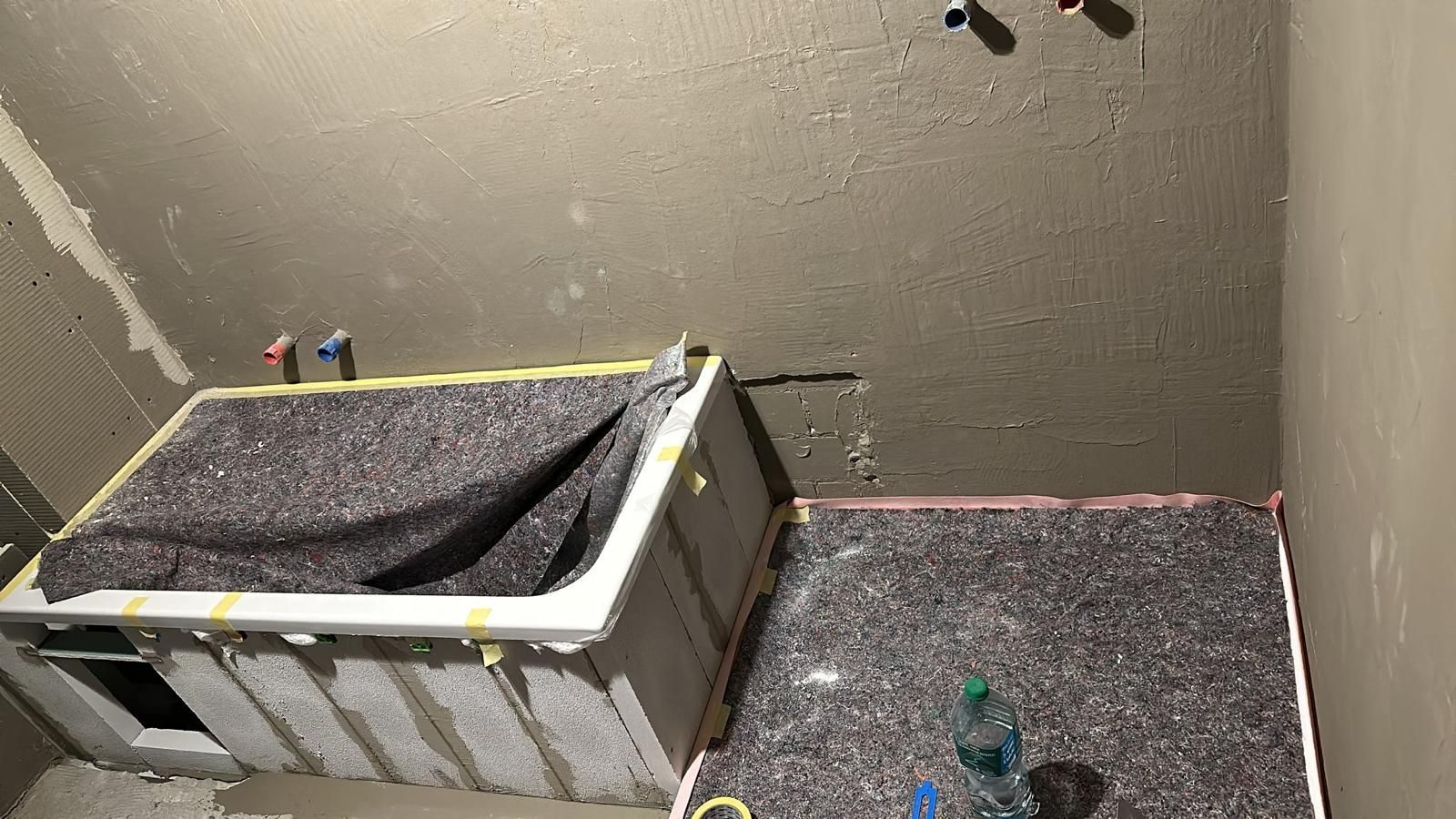 A bathtub is sitting on the floor in a bathroom under construction.