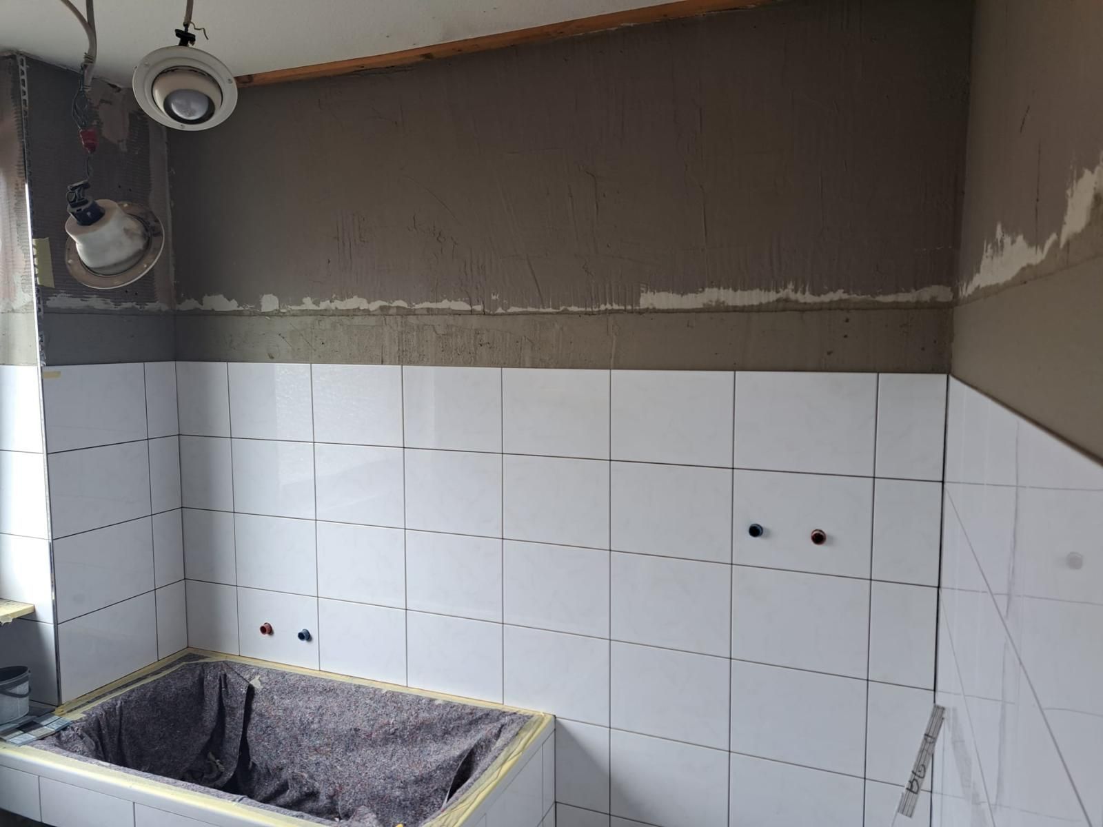 A bathroom with white tiles and a sink.
