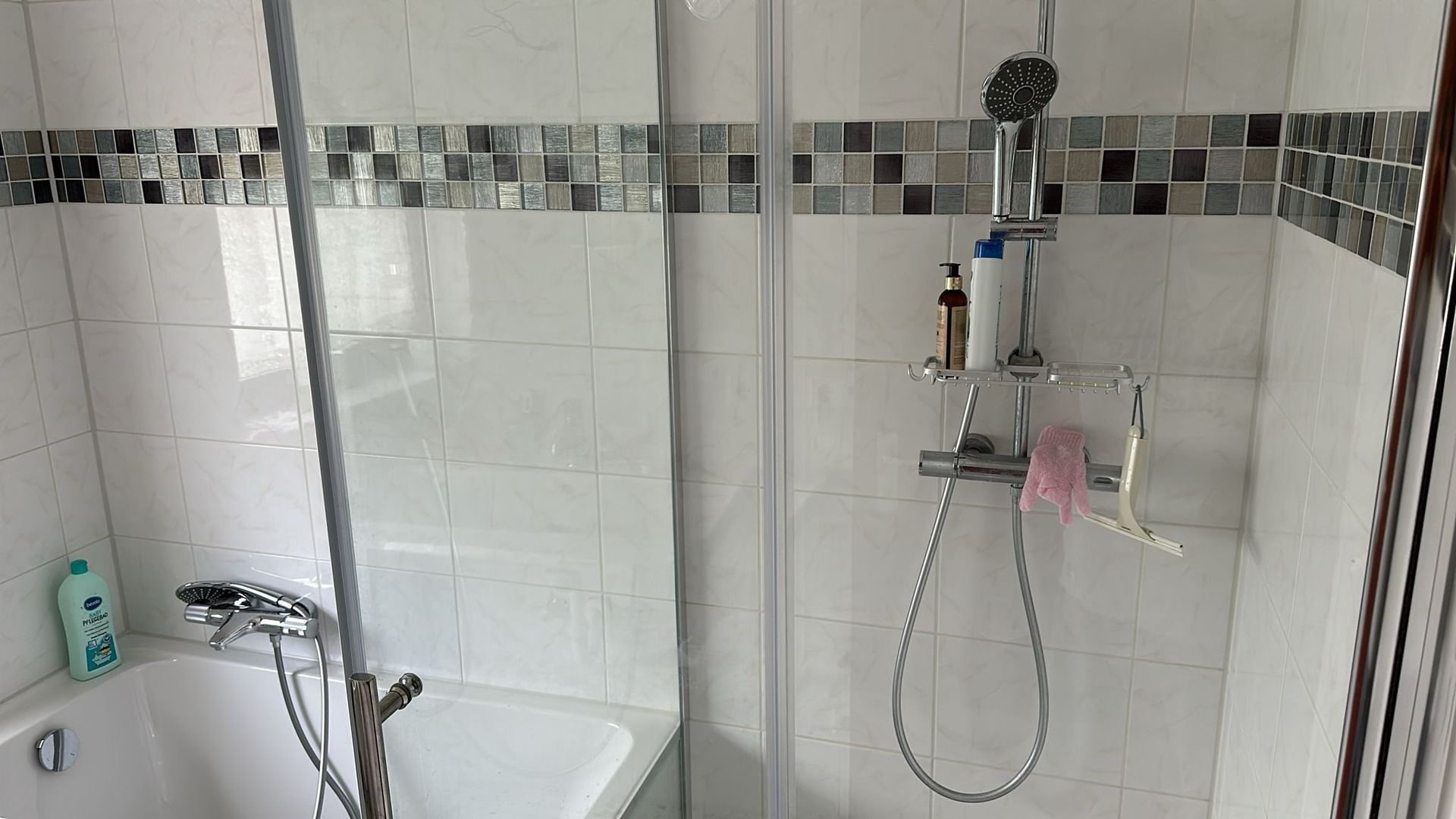 A bathroom with a bathtub , shower , and mirror.