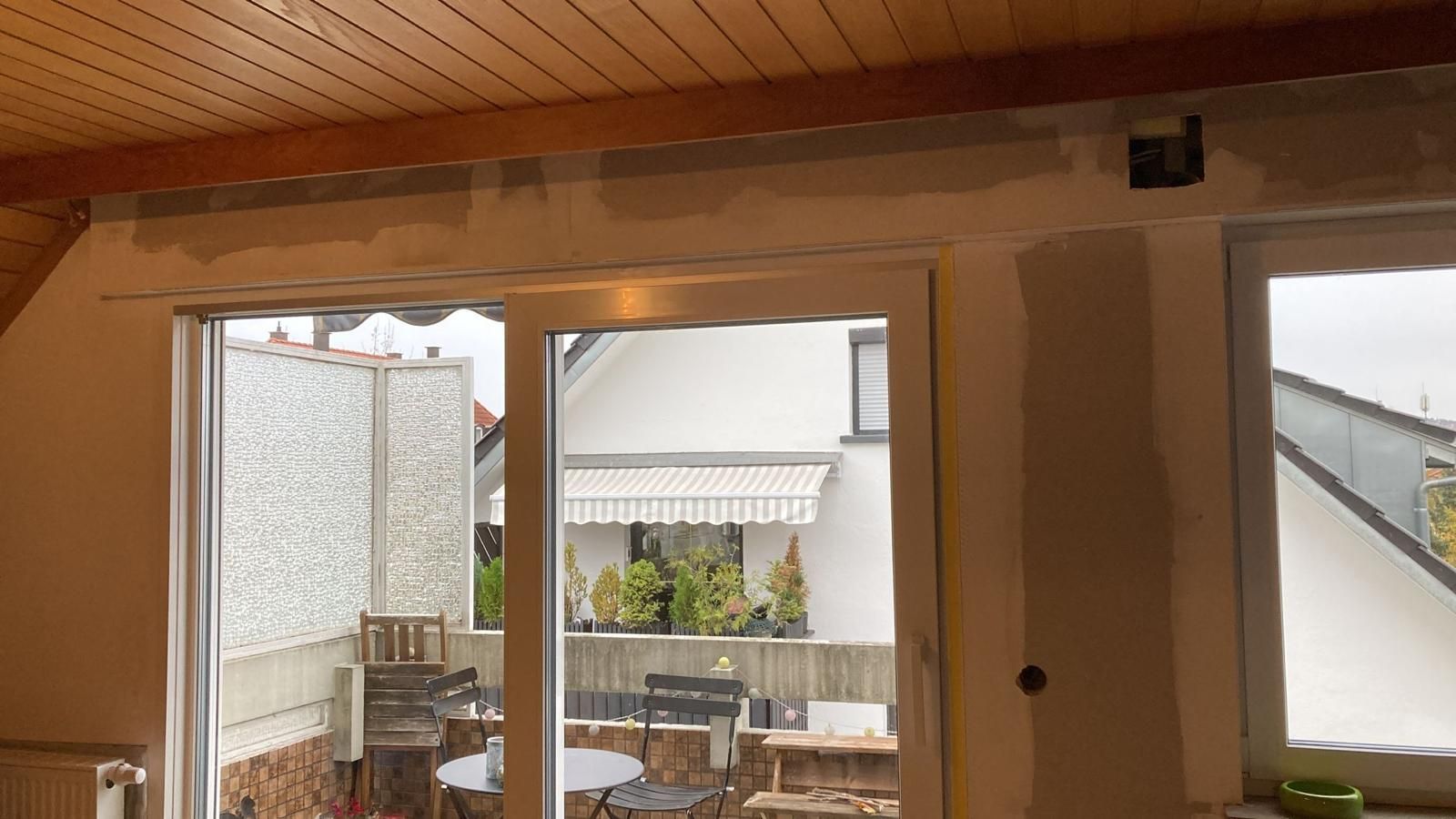 A room with a sliding glass door leading to a balcony.