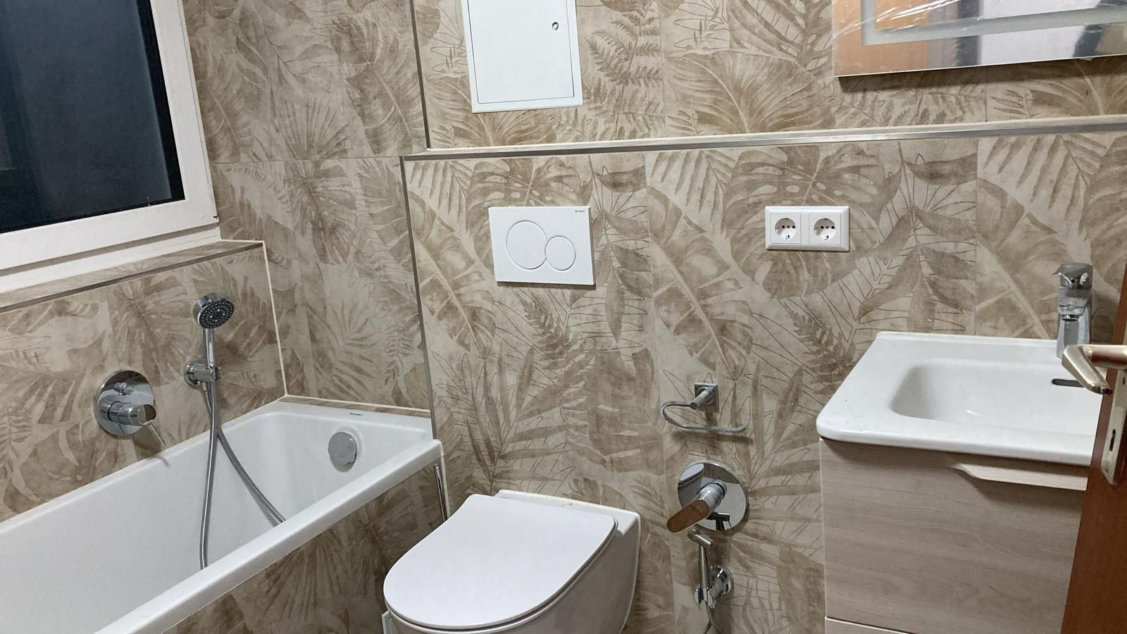 A bathroom with a bathtub , toilet , sink and mirror.