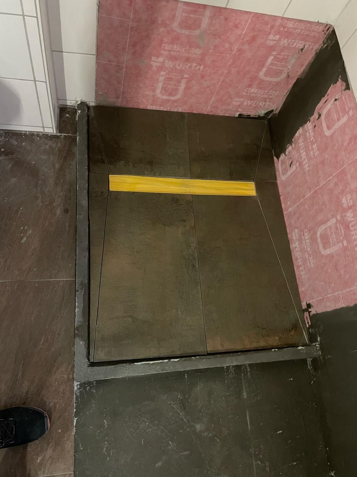 A person is standing in a room with a yellow line on the floor.