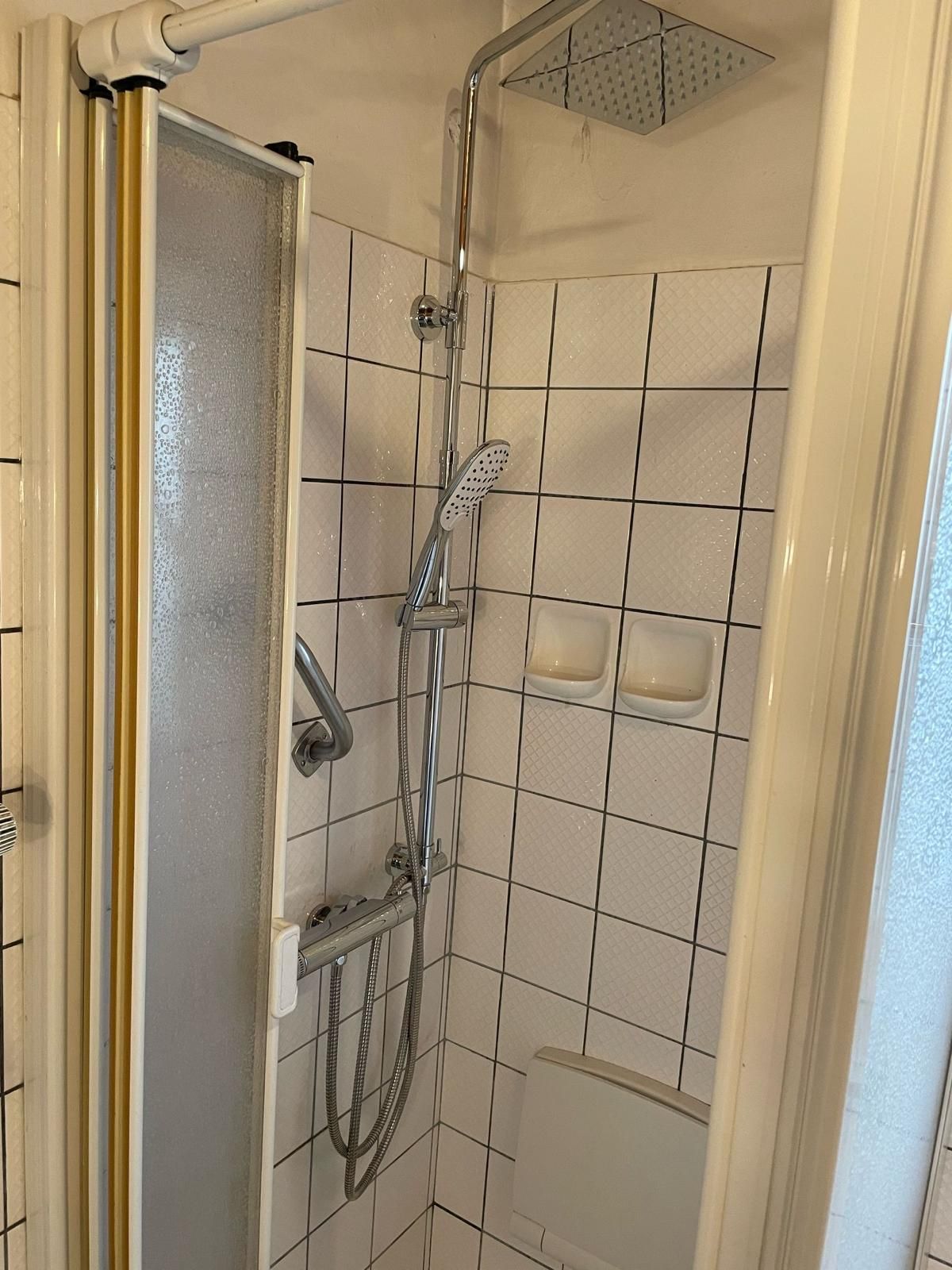 A bathroom with a shower stall and a toilet.
