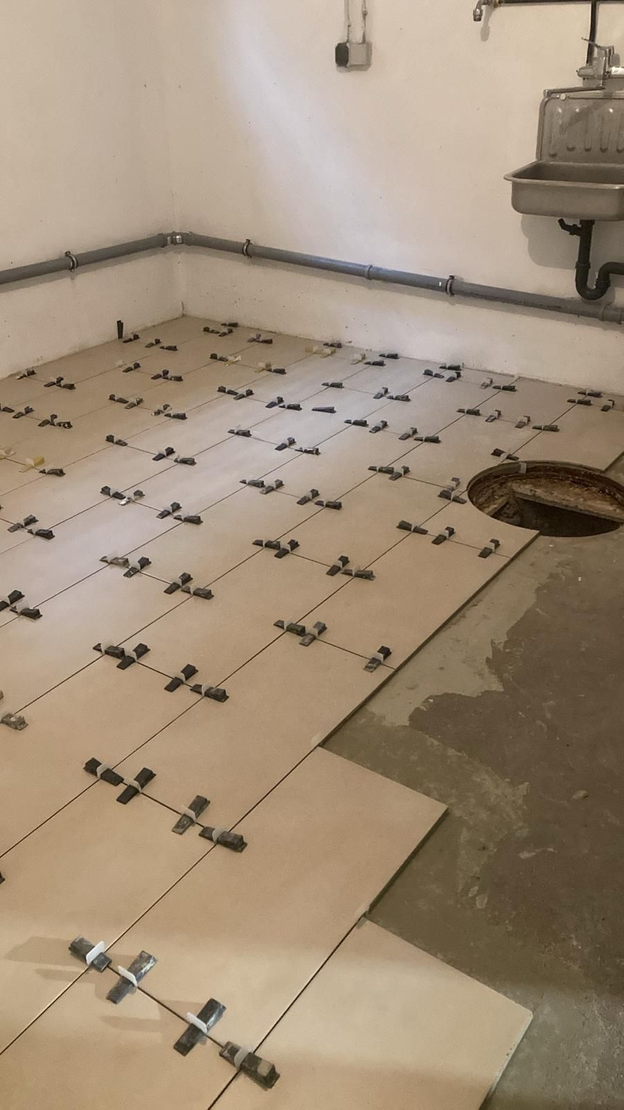 A room with a sink and a hole in the floor