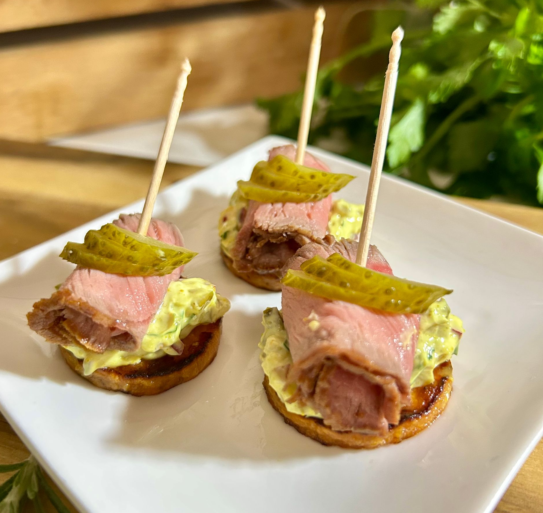 Vorspeise: Krabben- und Garnelensalat auf kleinen, goldgelben Blinis, garniert mit Dillzweigen.