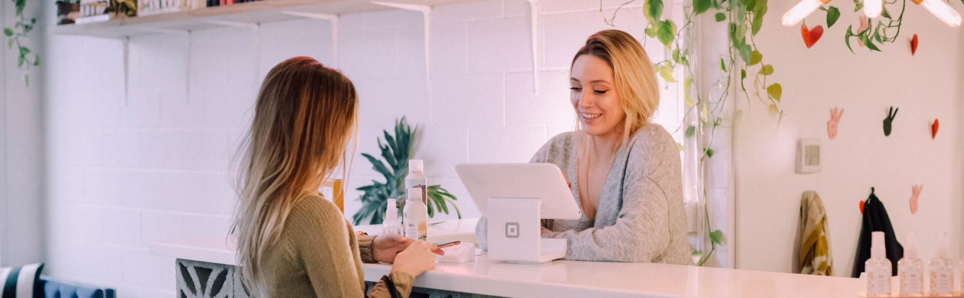 Two women are sitting at a table with a laptop.