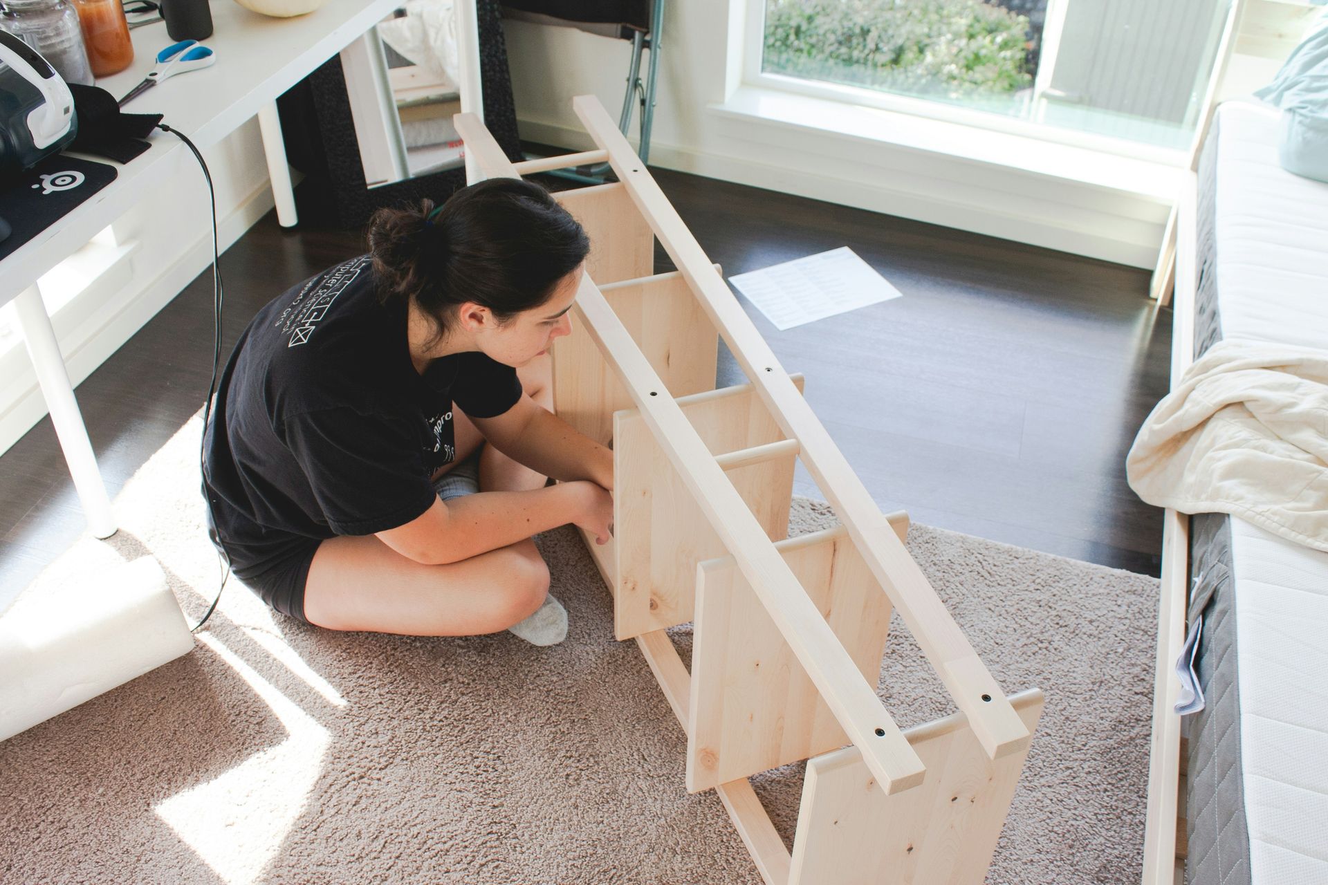 Disassembled furniture parts and instructions laid out on a cardboard surface.