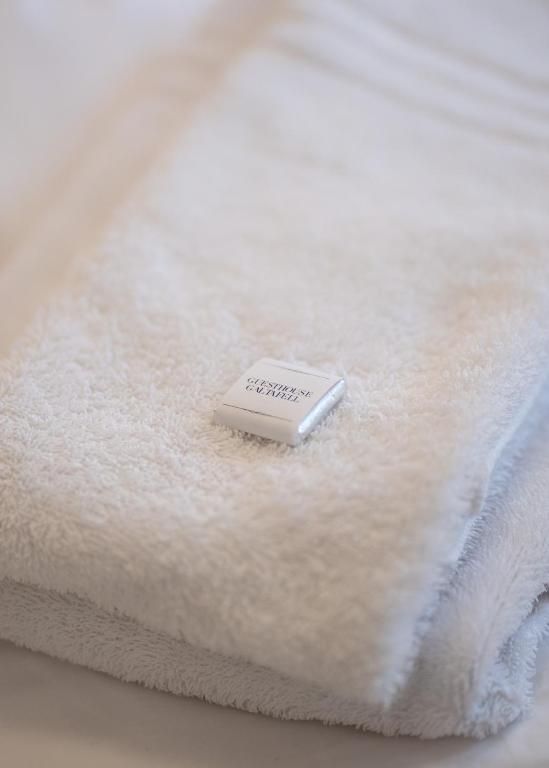 A small white hotel soap bar resting on a folded white towel.