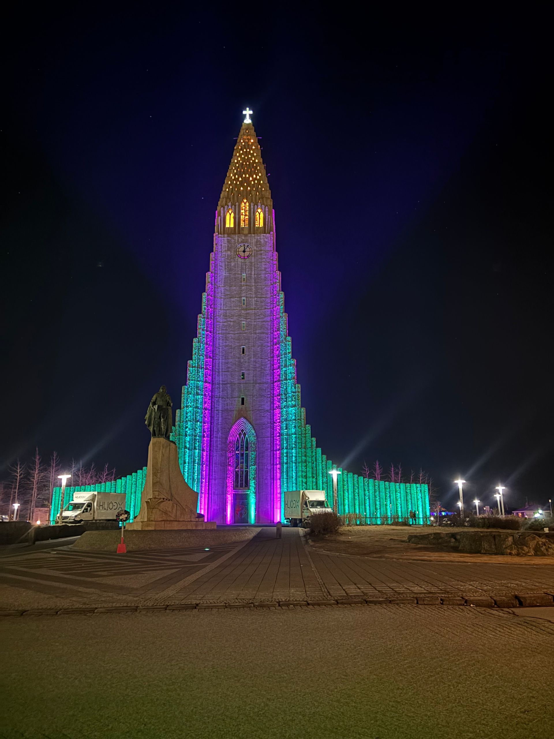 The Hallgrímskirkja church in Reykjavík, Iceland, with its distinctive concrete tiered tower under a blue, cloudy sky.