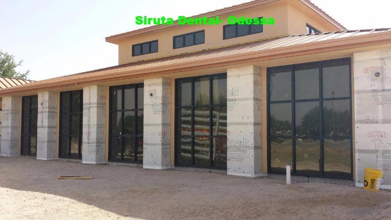 Modern storefront with large glass doors and stone columns under a tan awning