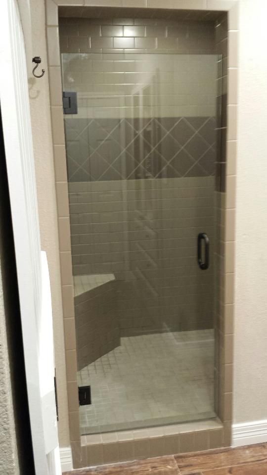 Glass shower door with chrome handle in a tiled bathroom or shower stall