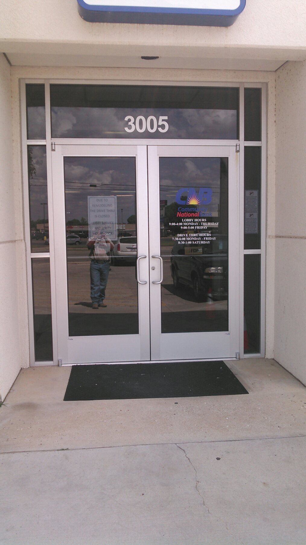 Glass double doors with number 3005 above, viewed from outside a building entrance.