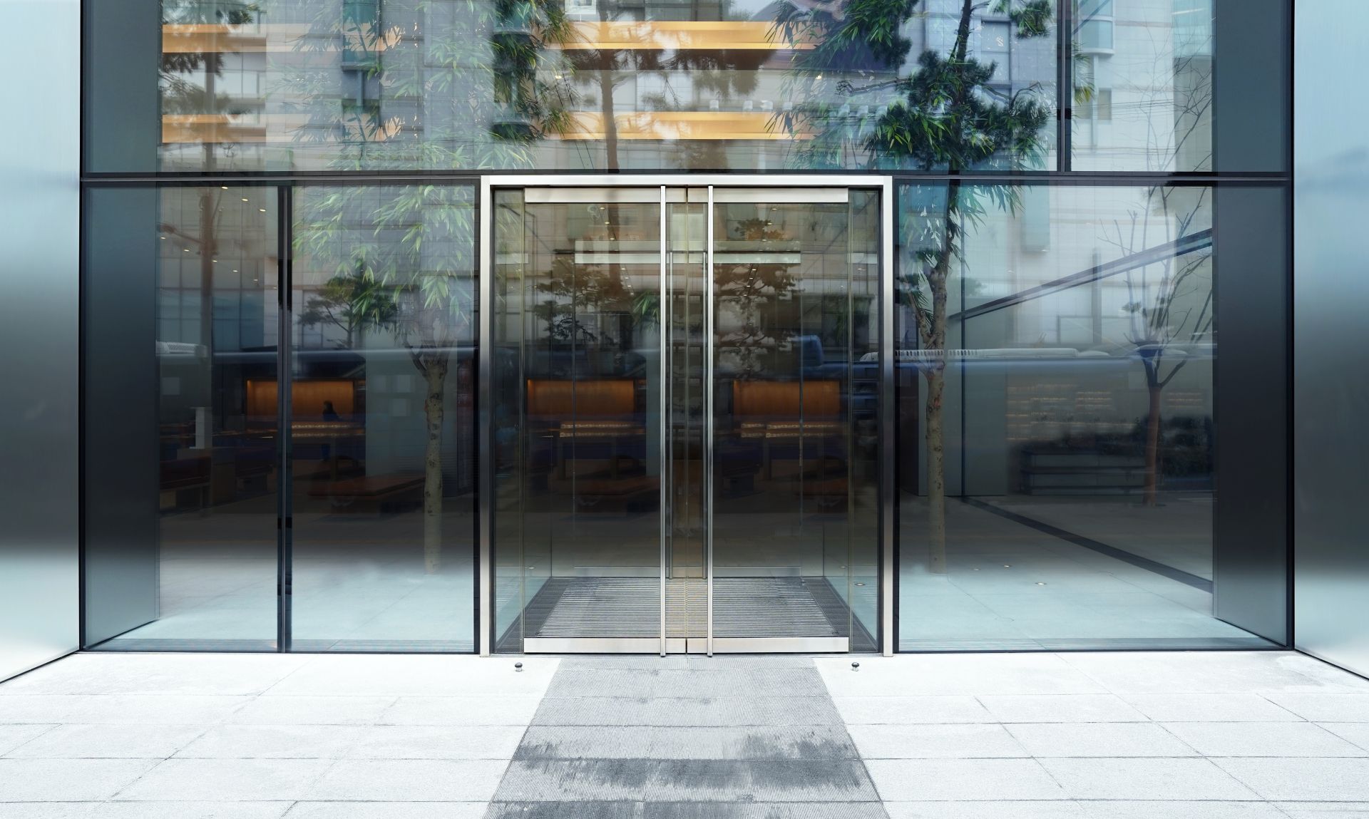 Modern glass office entrance with double doors and reflective windows in a sleek urban facade