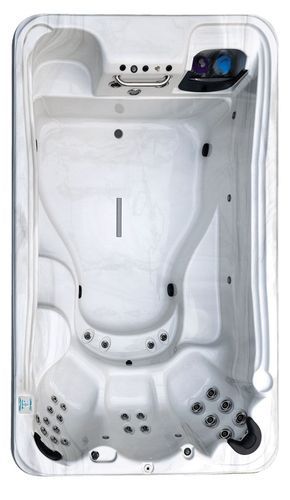 Top-down view of a white corner whirlpool bathtub with jets and built-in controls