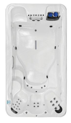 Top-down view of a white spa tub with molded seats, jets, and blue controls in the corner.