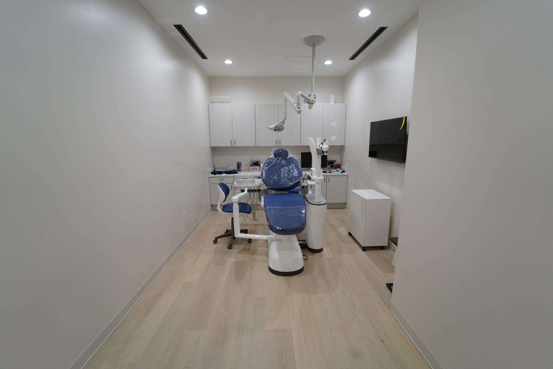 A woman is smiling while sitting in a dental chair.
