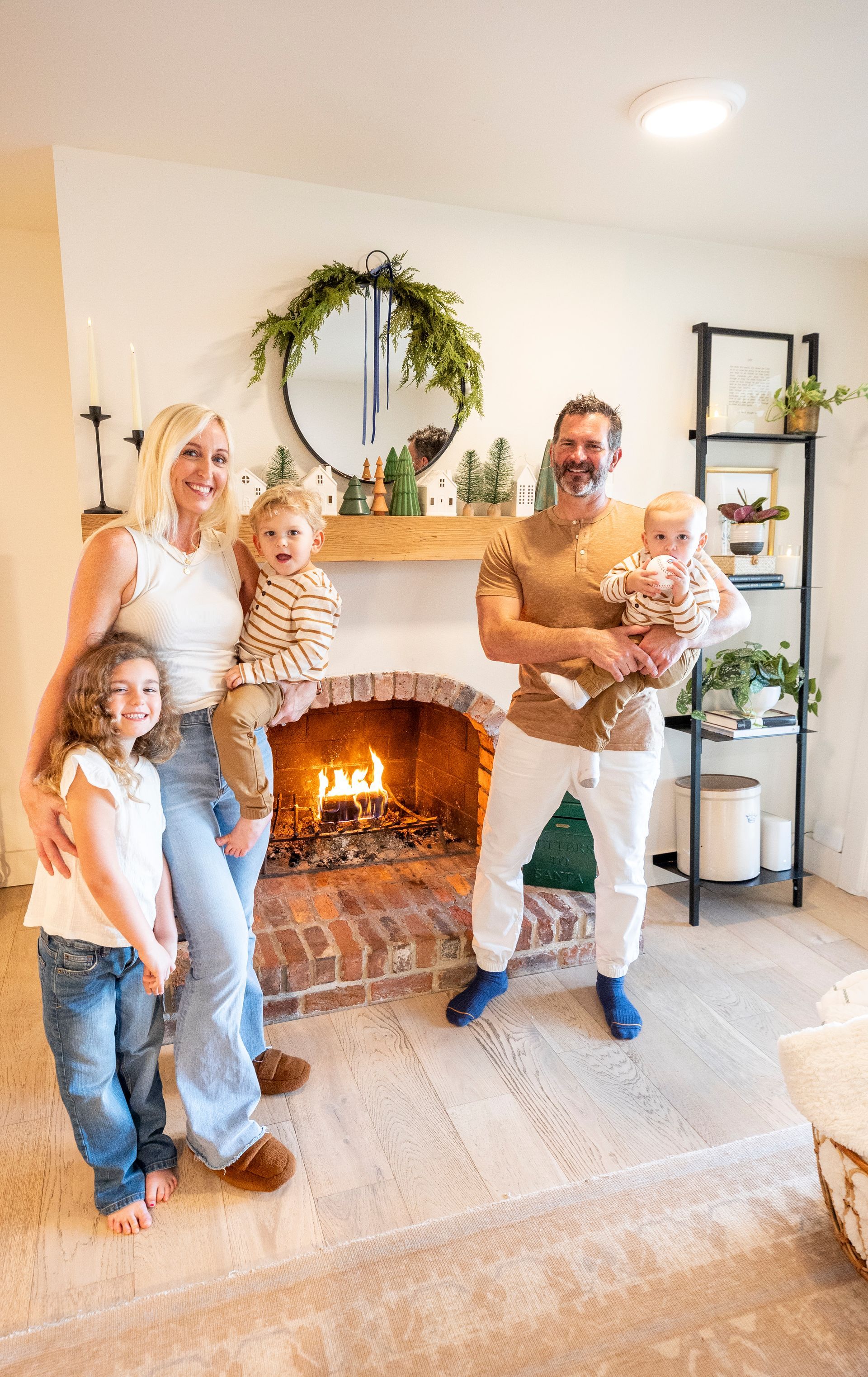 A family is standing in front of a fireplace in a living room.