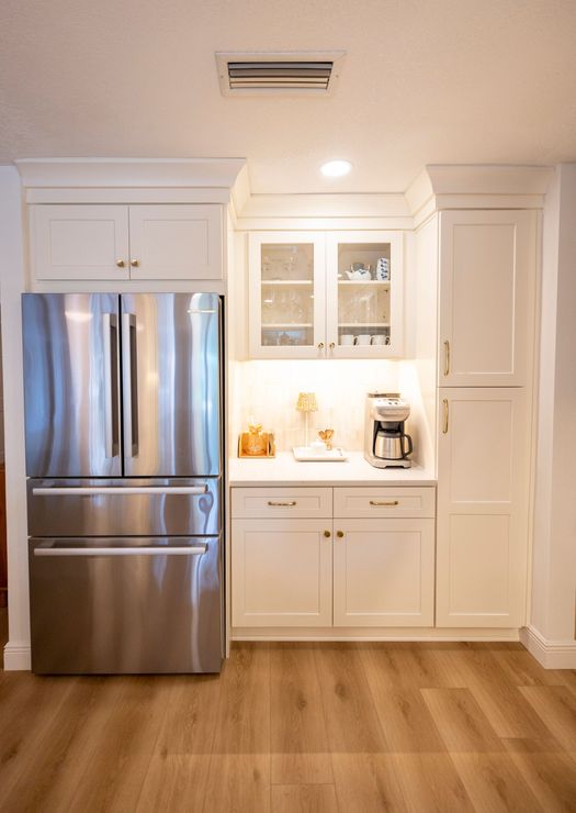A kitchen with stainless steel appliances and white cabinets.