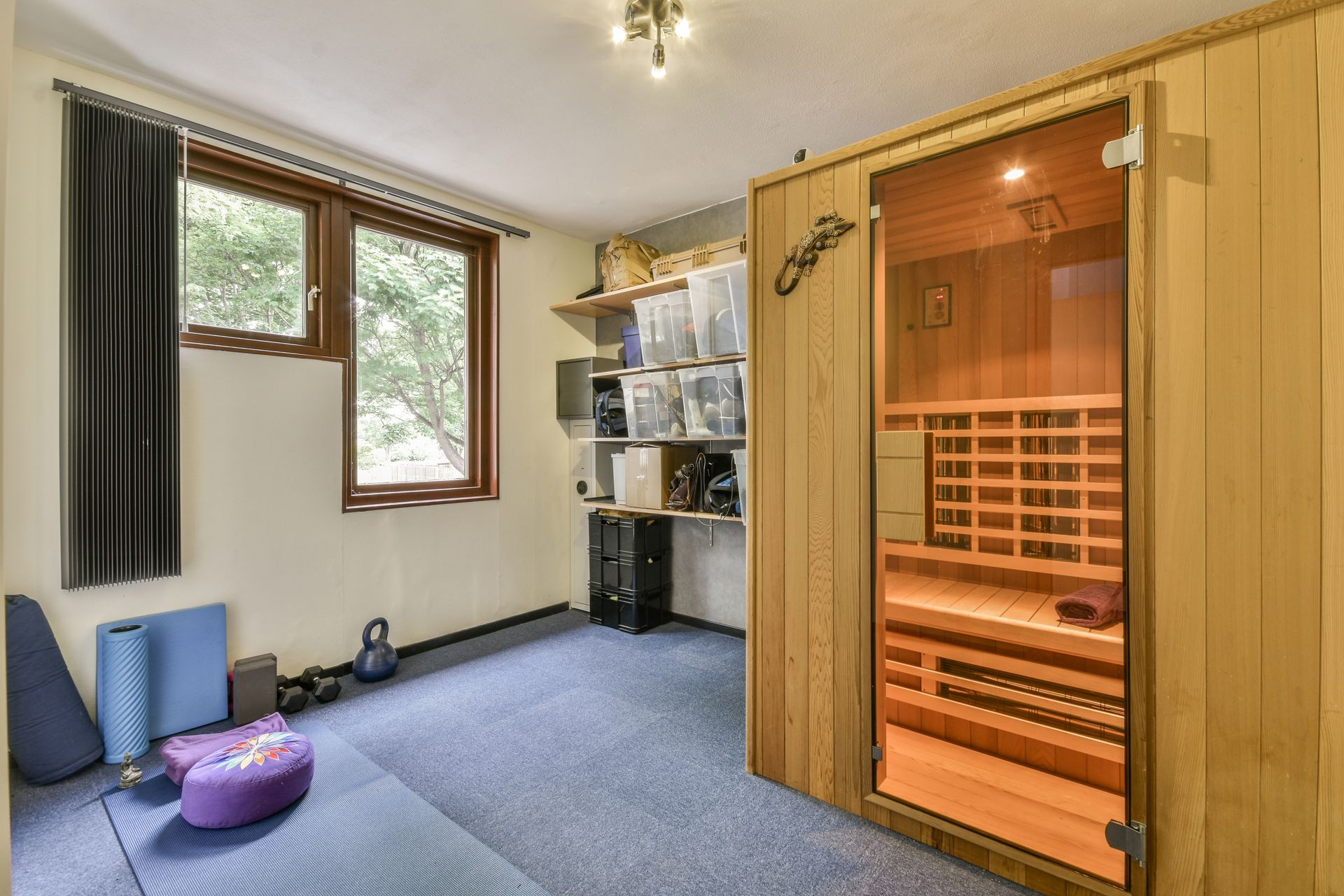 Cozy room with carpet, window, shelves, and a glowing wooden sauna booth, customized by BittnerSweet