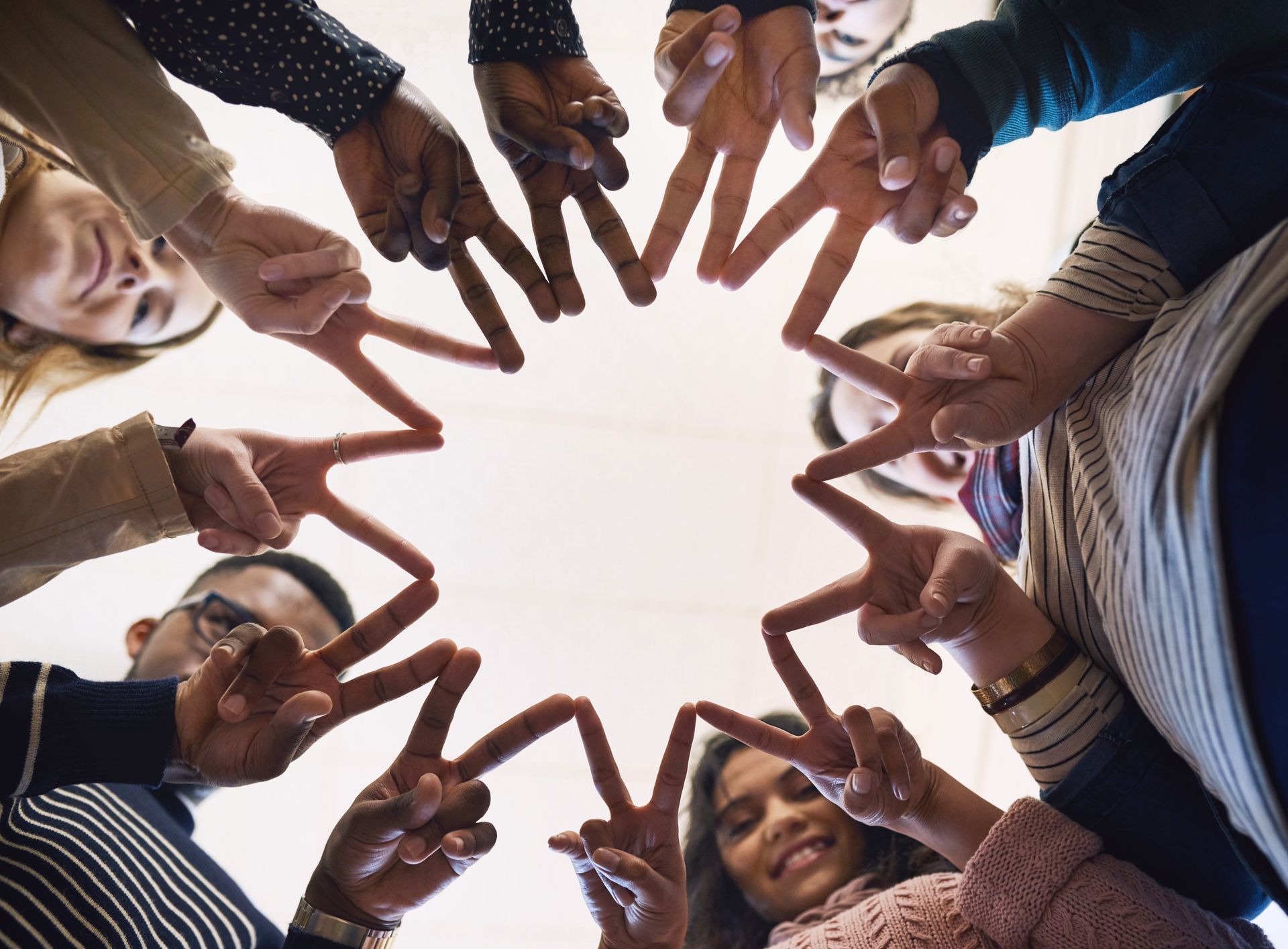 A group of people trying to create a shape with their fingers