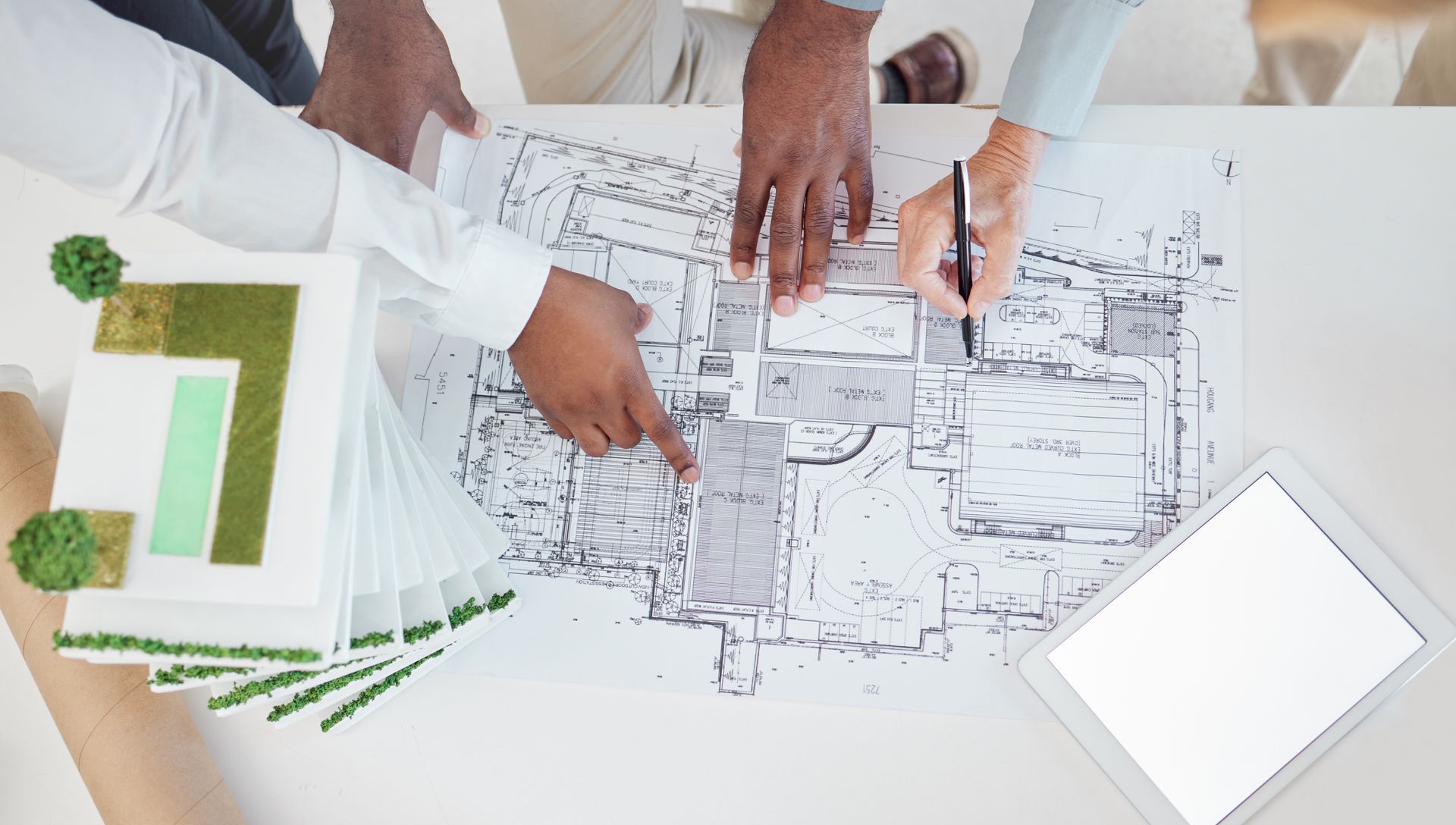A group of people are looking at a blueprint of a house.