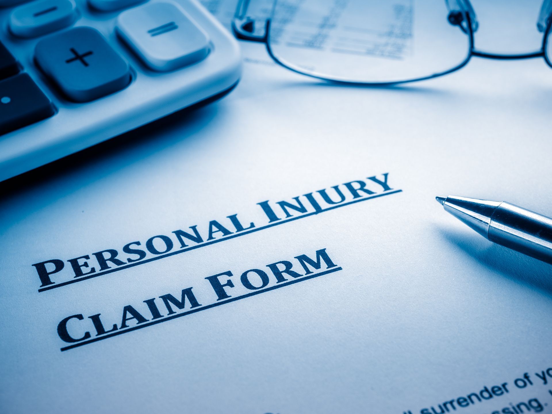 Personal injury claim document with pen and glasses, symbolizing legal process and documentation. Personal injury claim document with pen and glasses, symbolizing legal process and documentation.